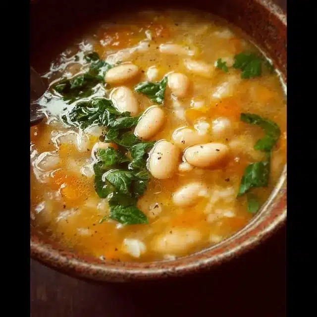 Bowl of delicious best white bean soup topped with fresh herbs