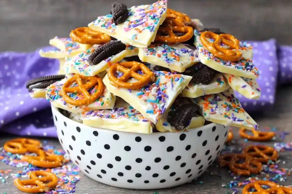 Easy Halloween Candy Bark 4 Colorful Halloween Candy Bark with sprinkles and chocolates on a white plate