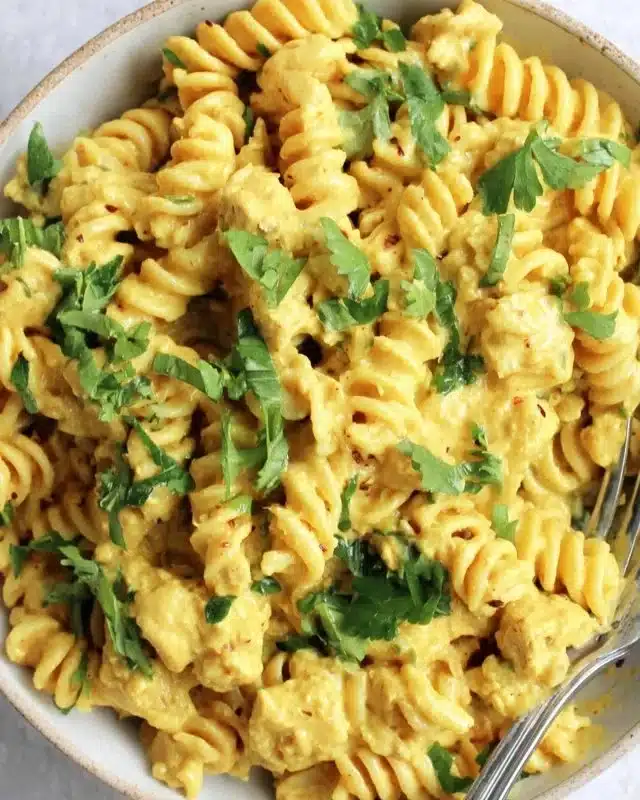 Bowl of creamy butternut squash pasta garnished with sage and thyme