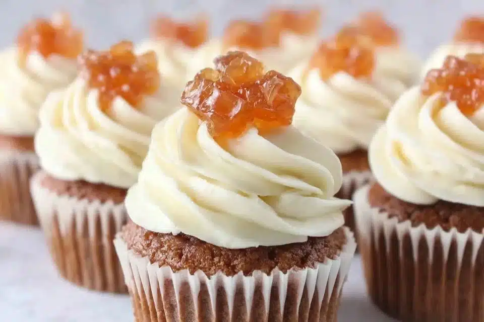 Delicious apple pie cupcakes with cinnamon frosting on a rustic wooden table