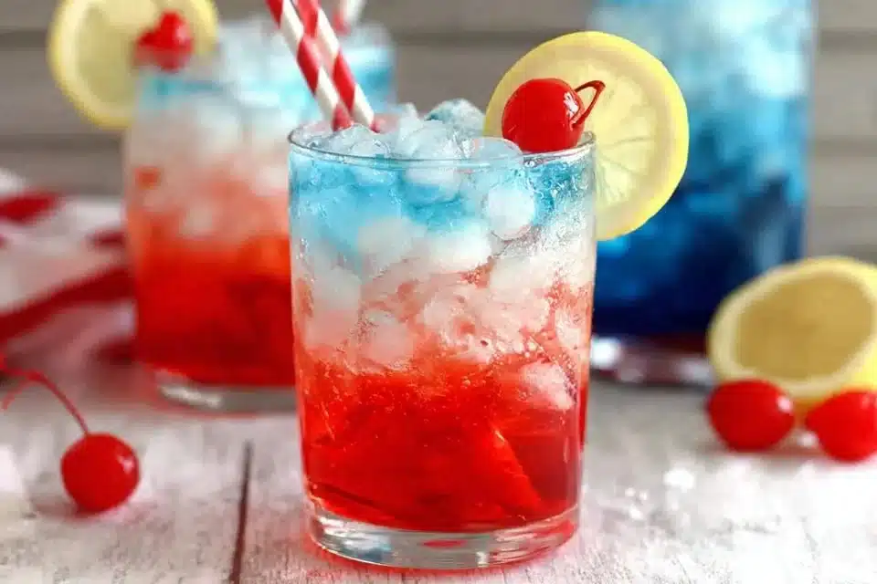 Festive red white blue cocktail garnished with fruit, ideal for summer parties.