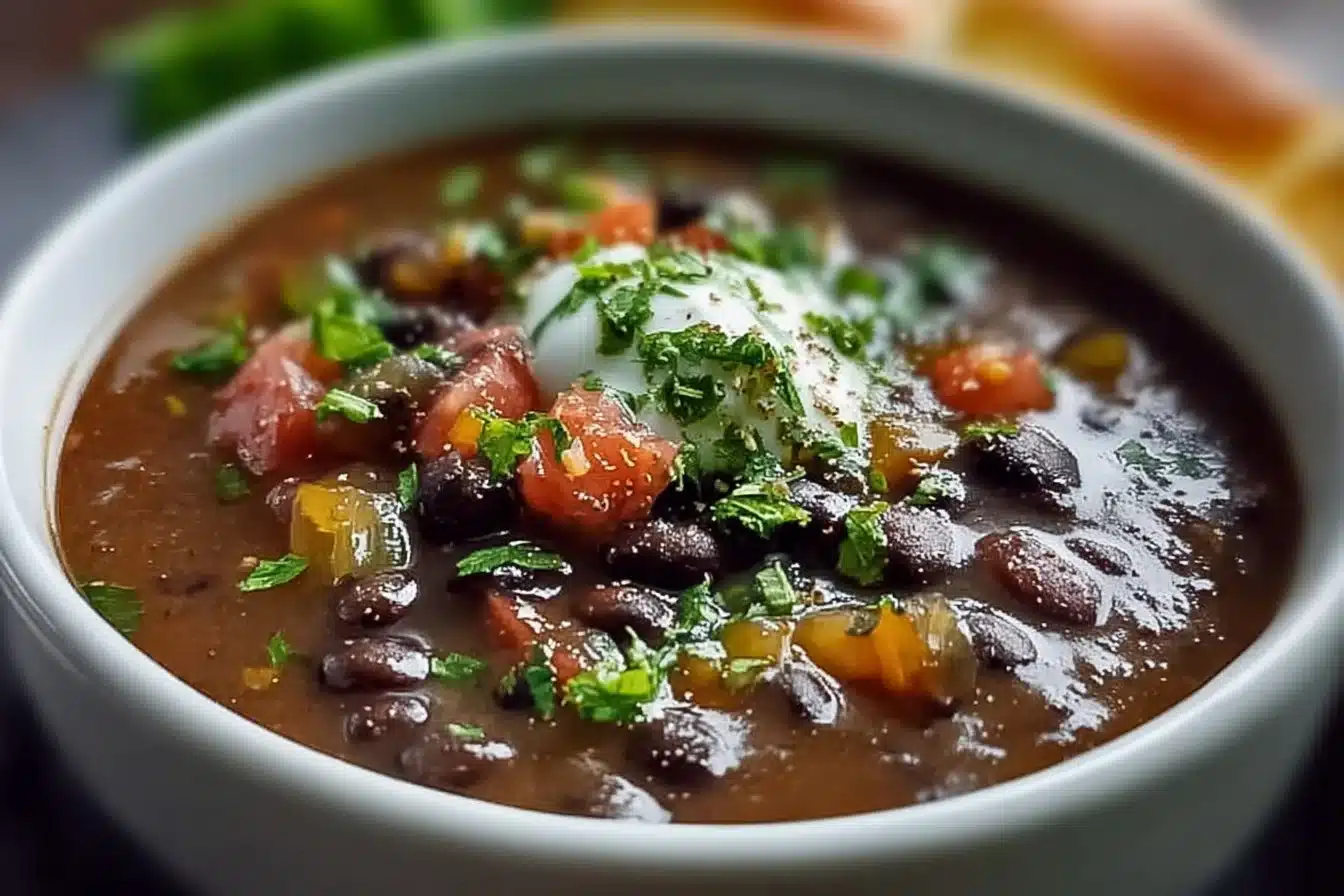 Bowl of hearty black bean soup garnished with herbs and spices