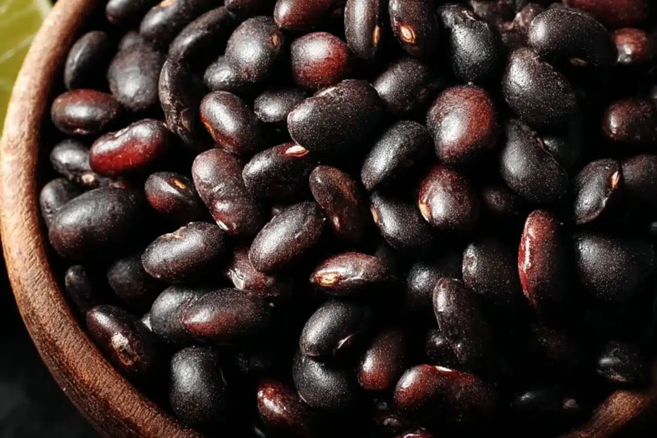 A bowl of delicious Mexican black beans garnished with fresh herbs.