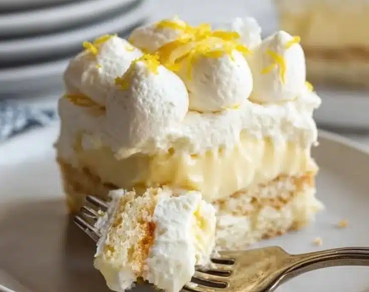 Sliced limoncello tiramisu with a lemon garnish on a wooden table