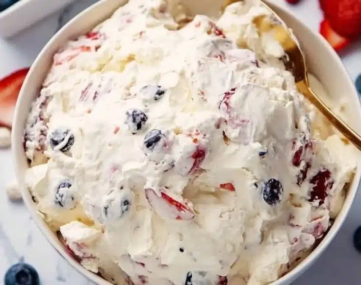Patriotic cheesecake salad with red, white, and blue berries in a bowl