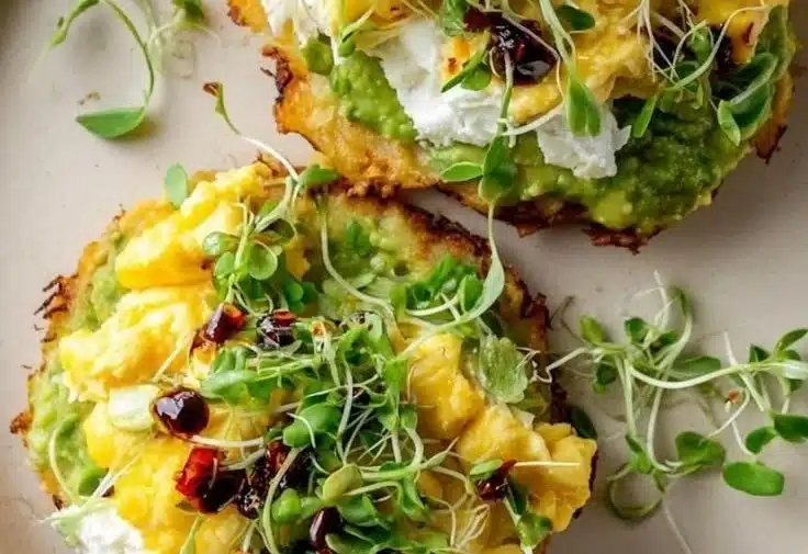 Crispy hashbrown avocado toast topped with fresh avocado slices and spices