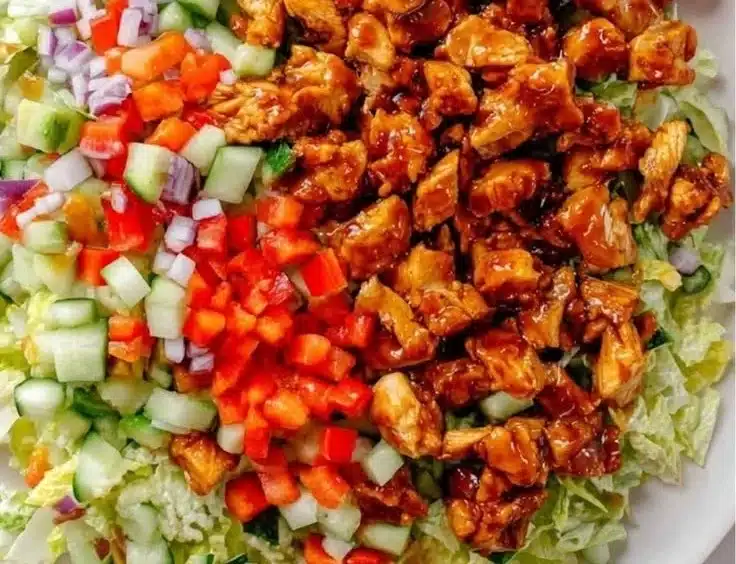 Honey-glazed spicy chicken salad bowl with fresh vegetables and dressing